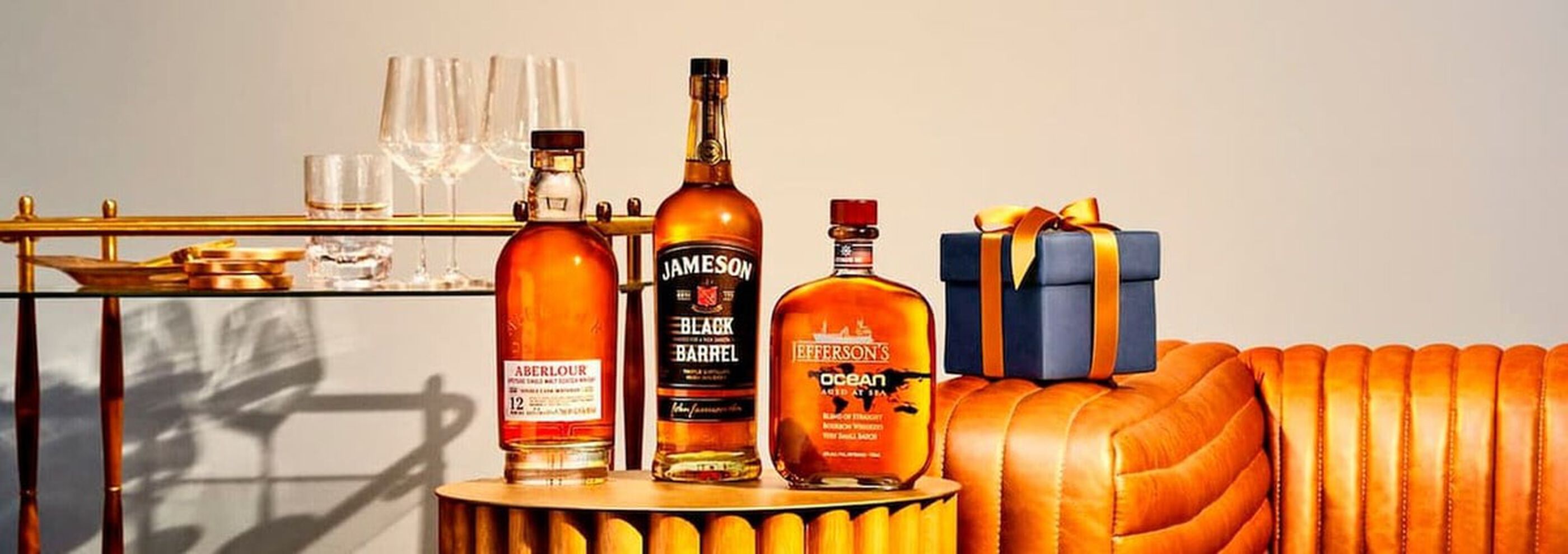 A collection of Father's Day spirits are ready to be opened on a leather couch